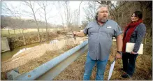  ?? Staff photograph by Jason Ivester ?? Jeff Clark and Ashley Kirby, both with Benton County Road Department, looked over a site recently where a bridge once crossed Limekiln Hollow Creek as part of Corinth Road in Garfield