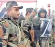  ?? ?? Syrian combatants hold posters bearing the Z symbol of the Russian invasion