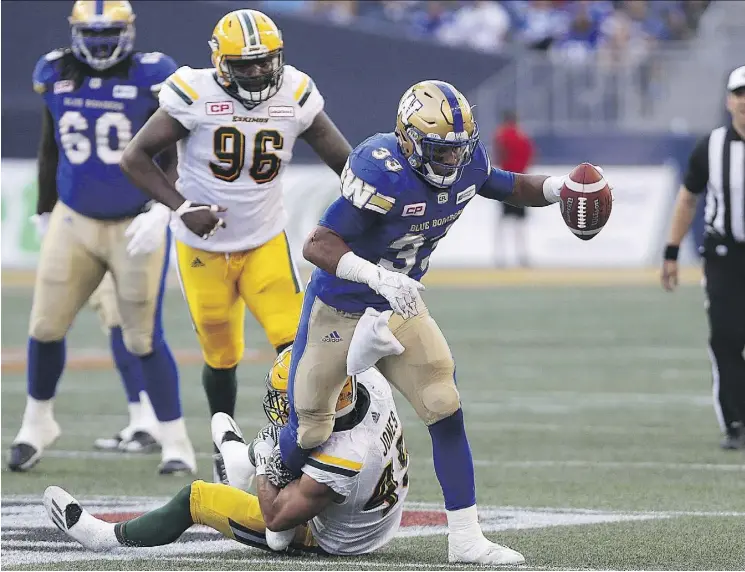  ?? KEVIN KING ?? Winnipeg Blue Bombers running back Andrew Harris fights for yardage as Edmonton Eskimos linebacker Korey Jones hangs on during CFL action on Aug. 17. Jones tore his ACL in this game and missed six games, but will be in the lineup when the two teams...