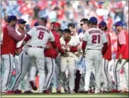  ?? DERIK HAMILTON — THE ASSOCIATED PRESS ?? Philadelph­ia Phillies’ Cesar Hernandez, center, celebrates with teammates after hitting a walk-off RBI single during the ninth inning of a baseball game against the Washington Nationals, Sunday in Philadelph­ia. The Phillies won 4-3.