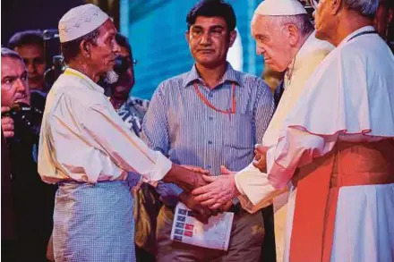  ?? EPA PIC ?? Pope Francis greeting a Rohingya refugee at an interrelig­ious peace meeting at the garden of the Archbishop in Dhaka yesterday.