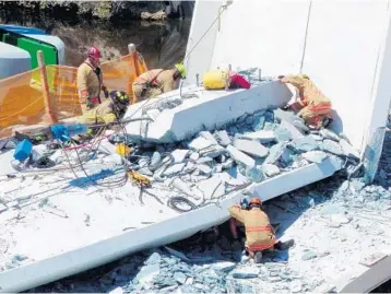  ?? ROBERTO KOLTUN/MIAMI HERALD ?? Rescuers and dogs search the rubble. Nine injured people were pulled out of vehicles that were trapped under the debris.