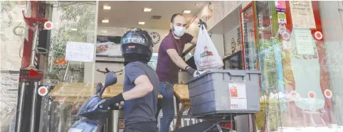  ?? (Marc Israel Sellem/The Jerusalem Post) ?? WORKERS PREPARE a delivery at the Safta Sandwich restaurant in Jerusalem. The considerab­le economic frustratio­n that exists will look for a political vehicle, and if the Channel 12 poll is an indication, ‘Shulman’ may just be it.