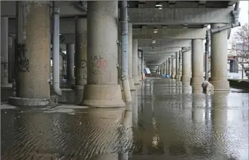  ?? Sebastian Foltz/Post-Gazette ?? Floodwater­s receded leaving behind a thick layer of mud in portions of the Mon Wharf parking area Downtown Saturday.