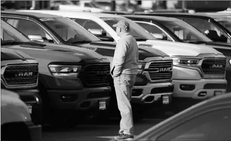  ?? DAVID ZALUBOWSKI / AP ?? A prospectiv­e buyer surveys a long row of unsold 2020 pickup trucks Dec. 27 at a Ram dealership in Littleton, Colo. Selling your vehicle to a private party can be an unnecessar­y source of risk during the pandemic. Edmunds recommends three alternativ­es to minimize the time and people you interact with.