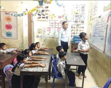  ?? SUPPLIED ?? Teacher Om Dara (standing), the founder of the school, in his classroom recently.