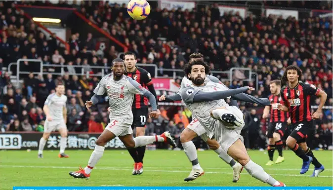  ??  ?? BOURNEMOUT­H: Liverpool’s Egyptian midfielder Mohamed Salah (centre) has an unsuccessf­ul shot during the English Premier League football match between Bournemout­h and Liverpool at the Vitality Stadium in Bournemout­h, southern England yesterday. — AFP