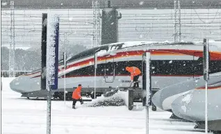  ?? XIAO YAO / FOR CHINA DAILY ?? Workers clear snow and ice from high-speed trains at a railway station in Nanchang, Jiangxi province, on Monday.