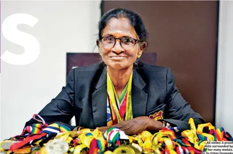  ?? ?? All smiles: A proud Akila surrounded by her many medals. Pic by Eshan Fernando