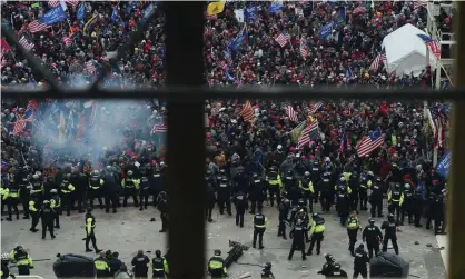  ?? Photograph: Olivier Douliery/AFP/Getty Images ?? Police hold back a mob of Trump supporters outside the US Capitol’s Rotunda on 6 January. Almost 600 people have been criminally charged for their part in the events.