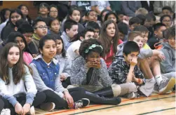  ??  ?? Milan Jermoljev, top, asks a question of astronaut Scott Tingle through a ham radio setup at Parkside Intermedia­te School in San Bruno. Assisting Milan are Janet Lutus and Nick Hart, the event coordinato­r. Students, above, gather in the gym to listen...