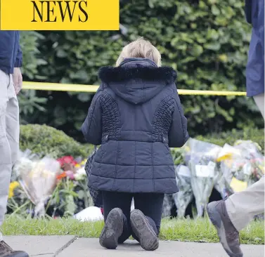  ?? DUSTIN FRANZ / AFP / GETTY IMAGES ?? A woman prays near the Tree of Life synagogue in Pittsburgh on Sunday after 11 people were killed in a shooting on Saturday. In the wake of the massacre, Canadian police department­s have put more officers around Jewish facilities.