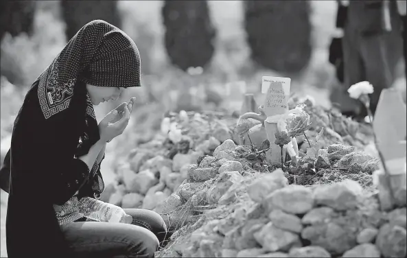  ?? ASSOIATED PRESS ?? EMRAH GUREL A woman prays at the grave of Ibrahim Duman, a 26-year-old man killed in a mine accident in Soma, Turkey. Officials suspect an explosion sparked a fire that killed at least 284 coal miners in the country’s worst mining accident.