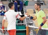  ?? MICHEL EULER/ASSOCIATED PRESS FILE ?? Novak Djokovic, left, and Rafael Nadal shake hands after their semifinal match at the 2021 French Open. Djokovic won that encounter; Tuesday night’s showdown is the first for the pair since last year’s Grand Slam in Paris.