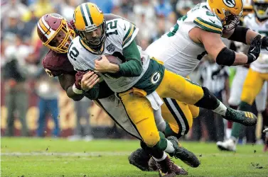  ?? AP Photo/Mark Tenally ?? ■ Green Bay Packers quarterbac­k Aaron Rodgers (12) is sacked by Washington Redskins defensive tackle Da’Ron Payne during the second half Sept. 23 in Landover, Md.