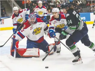  ?? JASON FRANSON ?? Seattle Thunderbir­ds forward Conner Roulette, right, is stopped by Edmonton Oil Kings goalie Sebastian Cossa during first-period Western Hockey League playoff action on Sunday at Rogers Place.