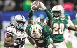  ?? Mike Stewart Associated Press ?? FLORIDA A&M defensive back Kendall Bohler intercepts a pass against Howard en route to A&M’s 11th consecutiv­e win, 30-26 in the Celebratio­n Bowl in Atlanta.