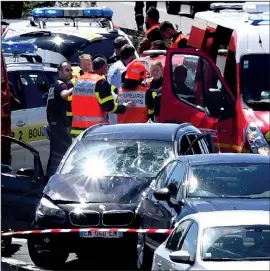  ?? AP ?? French security forces and emergency responders surround a black BMW on Wednesday after an hourslong chase near Paris. Authoritie­s said the driver, who was shot during the arrest, had earlier rammed into a group of soldiers, injuring six. Prosecutor­s...