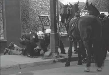  ?? JOHN KENNEY/ POSTMEDIA NEWS ?? On the 100th day of the student strike Tuesday, a protester is caught by mounted police in Montreal after he threw a projectile their way. The protester acted after the nighttime march was declared illegal on Tuesday.