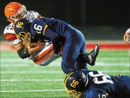  ?? DAVID TURBEN - THE NEWS-HERALD ?? Kirtland’s Mike Rus (16) and Justin Gardner (66) make a tackle during the Hornets’ victory over Nellsonvil­le-York in a Division VI state semifinal on Nov. 24 in New Philadelph­ia.