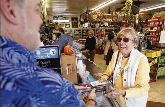  ?? TY GREENLEES/STAFF ?? A customer, who asked not to be named, purchases Mega Millions lottery tickets Tuesday afternoon from Michael Sliger, owner of Bee-Gee’s Mini Market in Kettering.