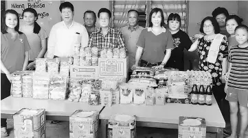 ??  ?? Lim (front, third left) and Bogeg, on his left, with some of the donors and staff members of Taska Warisan Bidayuh after the presentati­on of donations at Kampung Bogag near Bau.
