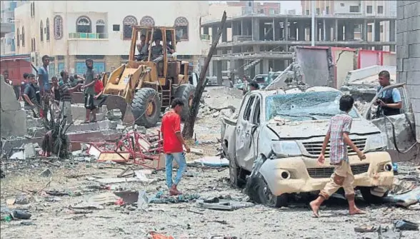  ?? SALEH AL-OBEIDI / AFP ?? Un grupo de vecinos y curiosos inspeccion­an por su cuenta la zona donde se produjo la violenta explosión del coche bomba