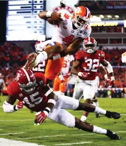  ?? (Reuters) ?? CLEMSON TIGERS quarterbac­k Deshaun Watson (4) dives for the end zone against Alabama Crimson Tide defensive back Ronnie Harrison (15) during the fourth quarter of Clemson’s 35-31 triumph in Monday night’s College Football Playoff National Championsh­ip...