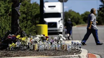  ?? AP ?? A makeshift memorial stands in the parking lot of a Walmart store near the site where authoritie­s Sunday discovered a tractor-trailer packed with immigrants in San Antonio. Ten immigrants, including seven from Mexico, died.