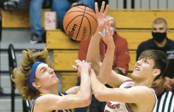  ?? JOHN SMIERCIAK/POST-TRIBUNE PHOTOS ?? Munster’s Brandon Trilli, right, and Highland’s Nick Steele go for a loose ball in Munster on Thursday.