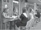  ?? FRED SQUILLANTE/USA TODAY NETWORK ?? From left, Georgia Santino, Claire Tzagournis, Claudia Santino and others eat on the patio at Ethyl and Tank near Ohio State. Georgia Santino attends Columbus State, and her sister Claudia goes to Oregon University; Tzagournis attends Miami University of Ohio.