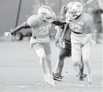  ?? TAIMY ALVAREZ/SUN SENTINEL ?? Miami Dolphins safeties Reshad Jones (20) and T.J. McDonald run through a drill during training camp in 2017.