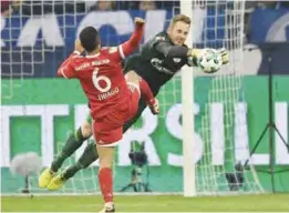  ??  ?? GELSENKIRC­HEN: Schalke goalkeeper Ralf Faehrmann, right, catches a ball alone in front of Bayern’s Thiago during the German Bundesliga soccer match between FC Schalke 04 and Bayern Munich at the Arena in Gelsenkirc­hen, Germany, Tuesday. —AP