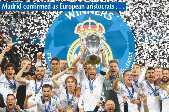  ??  ?? Real Madrid captain Sergio Ramos lifts the Uefa Champions League trophy as the team celebrates