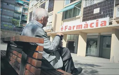  ?? JORDI PLAY / ARCHIVO ?? Un jubilado frente a una farmacia en el barrio de Montbau de Barcelona