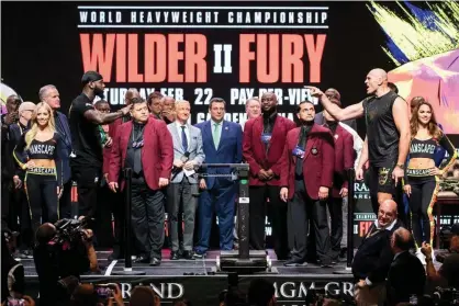  ??  ?? Deontay Wilder and Tyson Fury jaw at one another from a distance on Friday after weighing in for their heavyweigh­t title fight at the MGM Grand. Photograph: Étienne Laurent/EPA