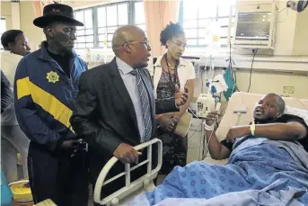  ?? /ANTONIO MUCHAVE ?? Police minister Bheki Cele, health minister Aaron Motsoaledi talk to Dr Lucky Kunene who survived an attack at Letaba Hospital.