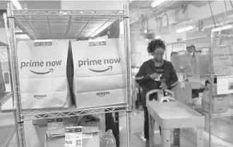  ?? MARK LENNIHAN/AP ?? Prime Now customer orders are seen at an Amazon warehouse. Miami was among the top five U.S. cities for last minute Amazon Prime Now orders on Christmas Eve.