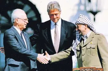 ?? FOTO: DPA ?? Der historisch­e Handschlag 1993 zwischen dem israelisch­en Ministerpr­äsidenten Jitzchak Rabin und PLO-Chef Jassir Arafat nach der Unterzeich­nung des Oslo-Abkommens in Washington unter Vermittlun­g von US-Präsident Bill Clinton.