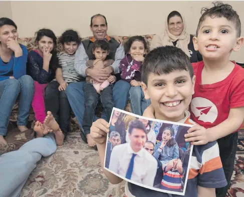  ?? STEPHEN MACGILLIVR­AY / THE CANADIAN PRESS ?? Abdel Kader Al Shaikh, 10, holds a photo taken of him during Prime Minister Justin Trudeau’s recent visit to Fredericto­n, N.B., on Saturday. The Canadian Press photo struck a chord with social media users, with some interpreti­ng the boy’s expression as...