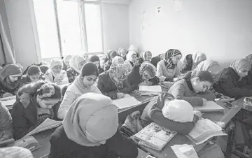  ??  ?? EDUCATION FOR REFUGEES: Female students at the Albashayer School for students upto college level, one of the few places for Syrian teenagers to continue their education in Turkey. • Male students arrive in the afternoon for classes at a high school for...