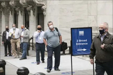  ?? MARK LENNIHAN — ASSOCIATED PRESS ?? New York Stock Exchange employees wait to enter the building as the trading floor partially reopens Tuesday.