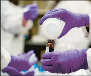  ?? AP ?? Water sample is poured into a container as part of drinking water and PFAS research at the U.S. Environmen­tal Protection Agency Center For Environmen­tal Solutions and Emergency Response in Cincinnati. Such PFAS, or “forever chemicals,” are limited in new legislatio­n.