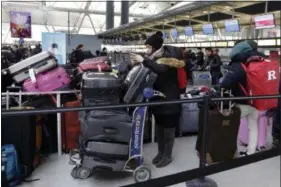  ?? RICHARD DREW — THE ASSOCIATED PRESS ?? Passengers at New York’s John F. Kennedy Airport Terminal 4 wait for flights, Monday. The Port Authority of New York and New Jersey said Monday it will investigat­e the water pipe break that added to the weather-related delays at Kennedy Airport and...