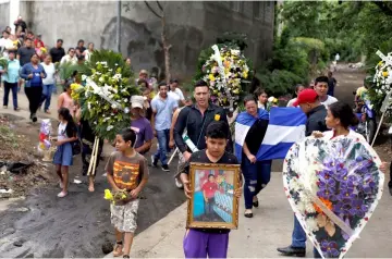  ??  ?? Relatives and friends carry wreathes and flowers as they arrive to the grave of the student Chester Chavarria, 19, who was killed during a protest against Ortega’s government, at the cemetery in Managua, Nicaragua. — Reuters photo