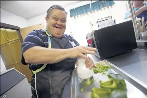  ?? PHOTOS BY BRANDON DILL/SPECIAL TO THE COMMERCIAL APPEAL ?? Thomas Robinson chops green peppers for a pot of chili at The Exceptiona­l Foundation kitchen inside Faith Christian Church. “I’m the best cook in town,” says Robinson, 49. The foundation, which provides services for intellectu­ally disabled people, is...