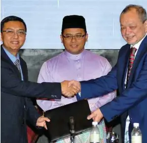  ?? BERNAMA PIC ?? Selangor Menteri Besar Amirudin Shari witnessing the handing over of the takeover offer letter from Air Selangor chief executive officer Suhaimi Kamaralzam­an (left) to Splash chairman Tan Sri Wan Azmi Wan Hamzah in Subang Jaya yesterday.