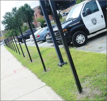  ??  ?? Above, some metal fence posts have already been installed along the Clinton Street side of Woonsocket Police headquarte­rs parking facility as noted during an announceme­nt of the project by Police Chief Thomas Oates last Friday. Fence paneling is being installed this week.