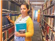  ?? ASSOCIATED PRESS ?? Alexandra Flores, 29, works as a library assistant while pursuing a master’s degree in library science. She credits the Obama health law for her decision to go back to school rather than be locked into her previous office job.