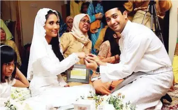  ?? — SAM THAM / The Star ?? Tying the knot: National bowler Zulmazran Zulkifli and his bride Rushmirin Asni exchanging rings in Petaling Jaya yesterday.